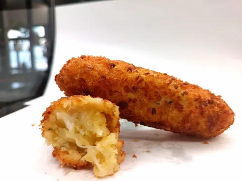Crocchette di patate tagliate a metà, con filo di mozzarella filante