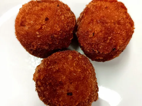 Tre olive ascolane impanate e fritte su un piatto