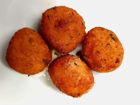 Quattro pallotte cacio e uova fritte su un piatto