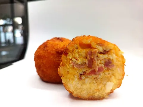 Arancino Zucca e Speck tagliato a metà, ripieno con speck e gorgonzola