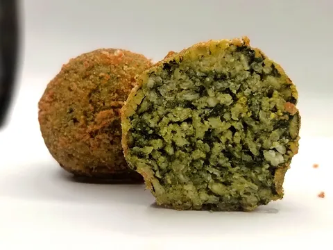 Arancino Spinaci e Pecorino tagliato a metà, ripieno verde di spinaci