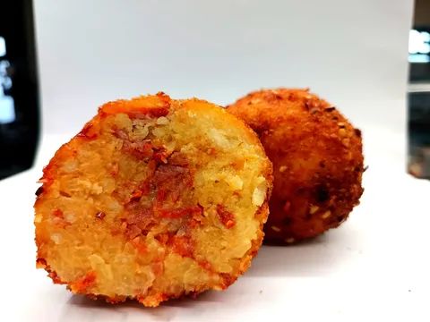 Arancino Ventricina e Provola tagliato a metà, ripieno giallo zafferano con ventricina e provola affumicata